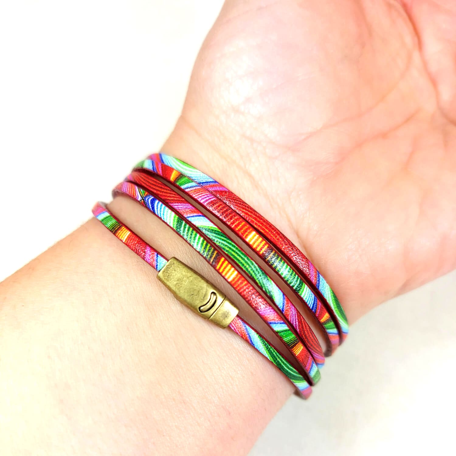 bracelet multicolore rose vert orange porté au poignet 5 lanières fermoir bronze