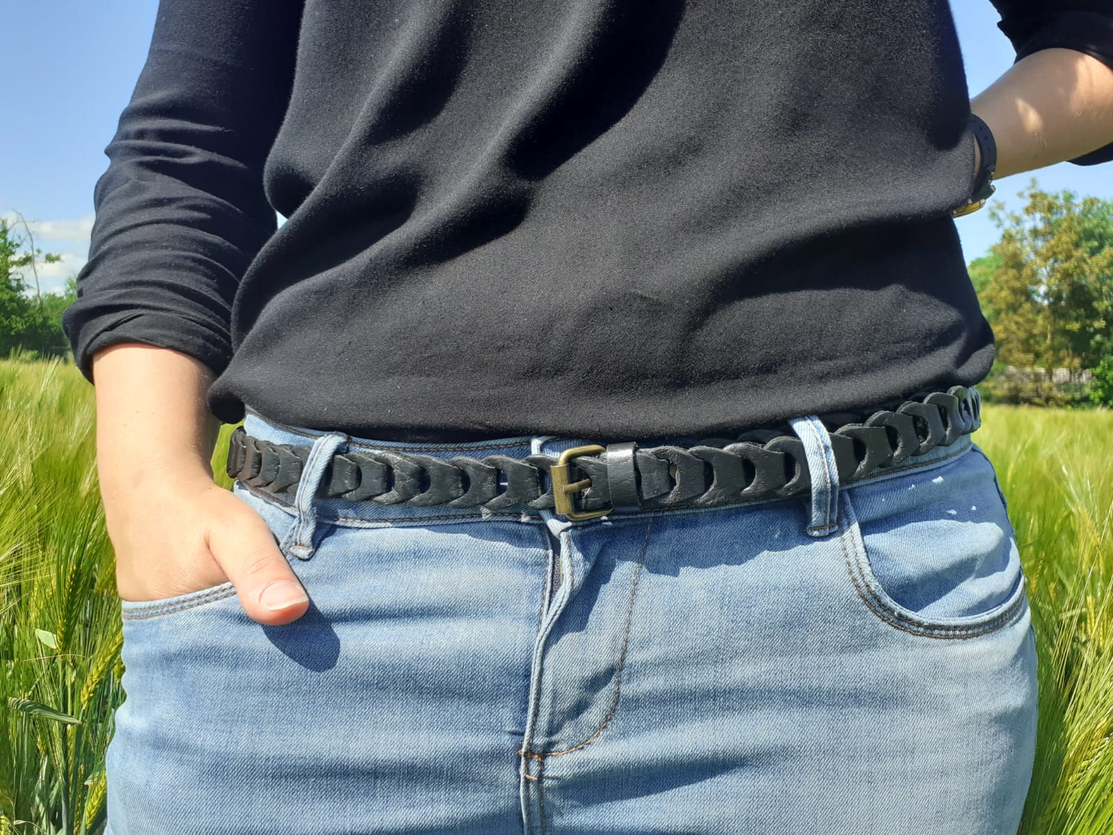 Ceinture fine en cuir noir à maillons portée sur un jean